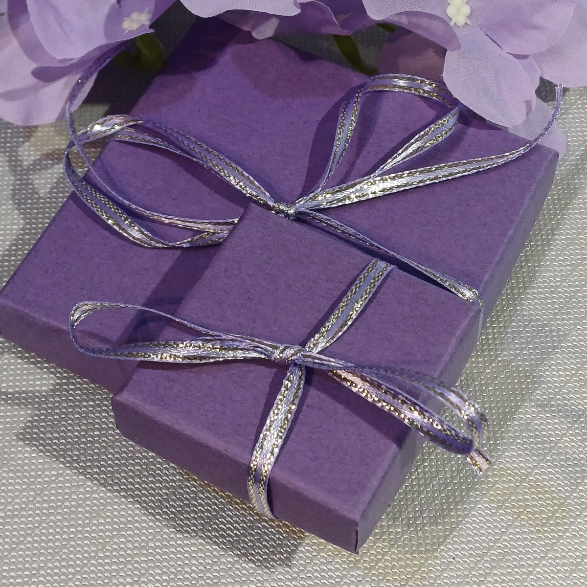 Silver 54 purple gift boxes tied with lilac and silver ribbon